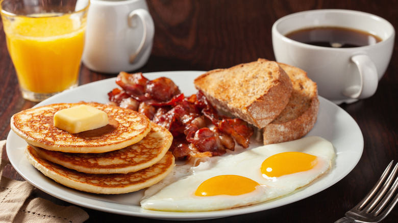Eggs, pancakes, toast, and bacon on a plate