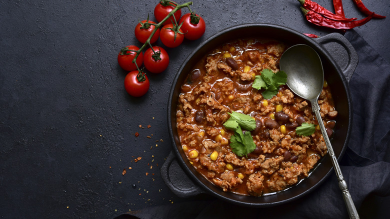A skillet of chili with cilantro on top