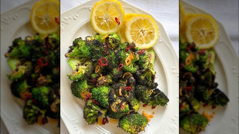 Broccoli with chili crisp and lemon halves on plate