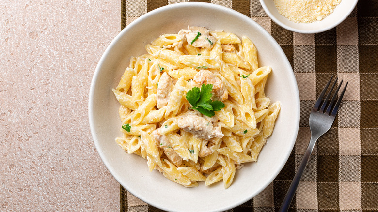 creamy chicken and penne pasta in a white bowl