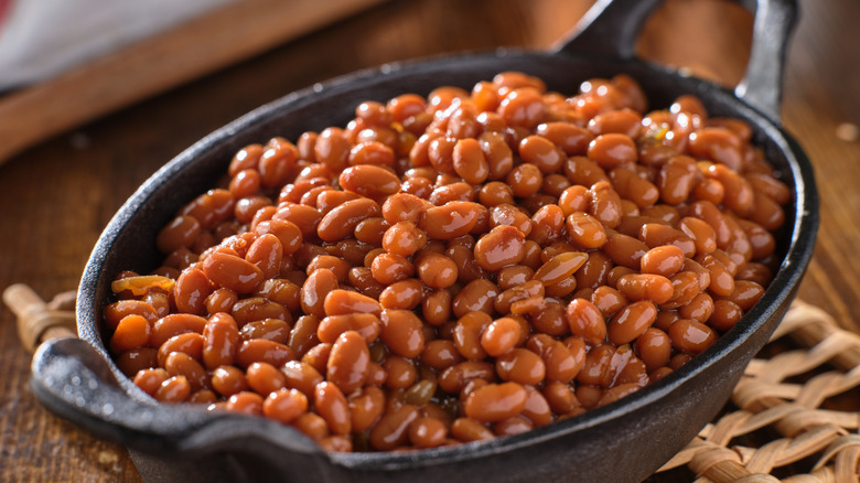 A cast iron bowl full of baked beans