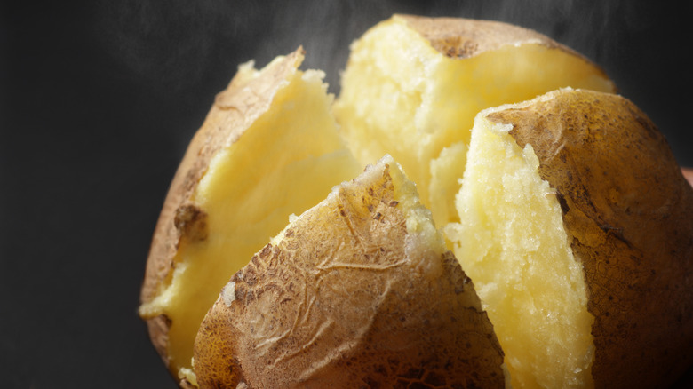 A baked potato cut and steaming