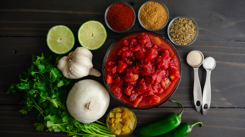 Small bowls of fire-roasted salsa ingredients laid out on a table