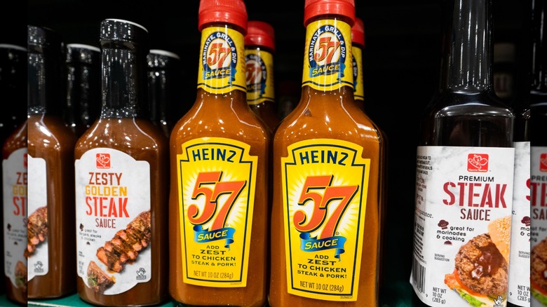 bottles of Heinz 57 sauces on grocery store shelf next to other steak sauces