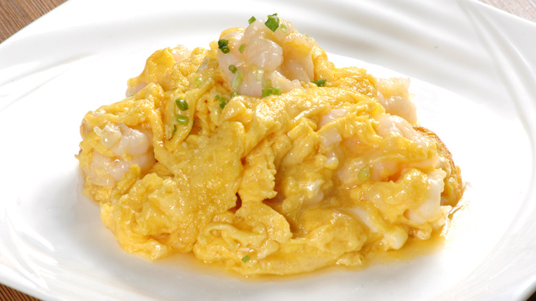 close up of of Chinese scrambled eggs with shrimp on white plate