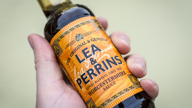 a hand holding a bottle of Lea and Perrins Worcestershire sauce
