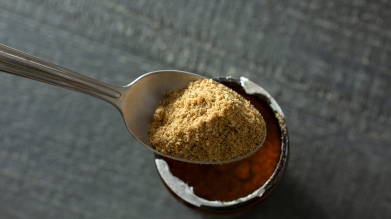 Aerial view of beef bouillon scooped in spoon from a container