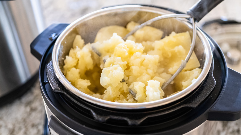 Two hands adjusting an Instant Pot pot lid