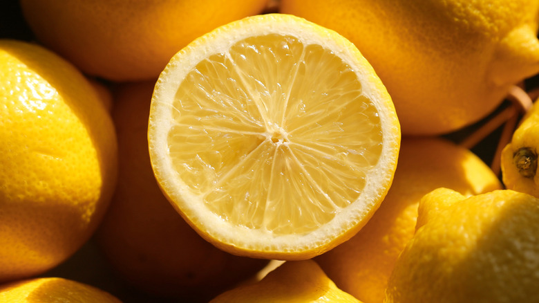 cut half of a lemon surrounded by lemons