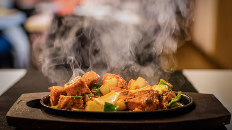 A fresh plate of steaming hot food, with visible steam rising.
