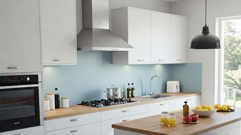 Kitchen interior with blue backsplash, wooden counters and white cabinets