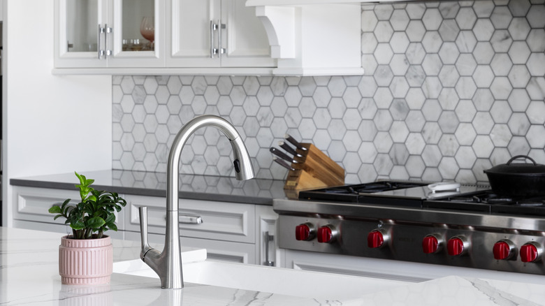 Kitchen sink detail with hexagon tiled backsplash in the background