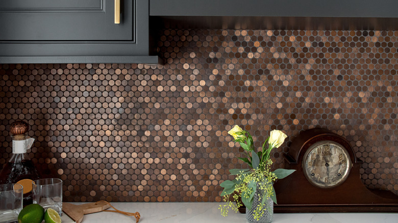 Closeup of brown penny tile on kitchen backsplash with black cabinets