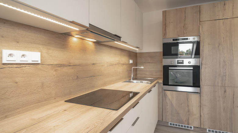 Modern kitchen with wooden backsplash and cabinets