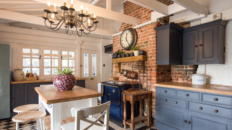 A Tuscan-style kitchen with exposed brick walls, wooden tables, and rustic decor