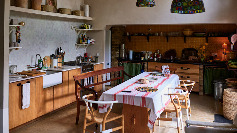 An empty Tuscan kitchen with a large dining table and chairs