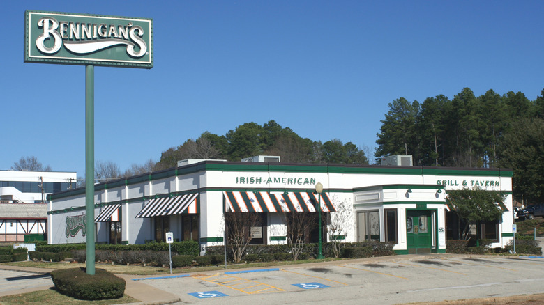 Exterior of Bennigan's restaurant with tall green sign