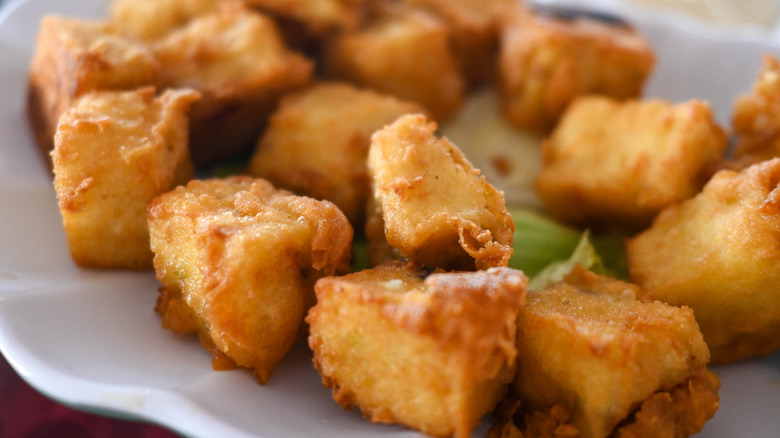 A close-up of cubes of extra-crispy tofu on a white plate