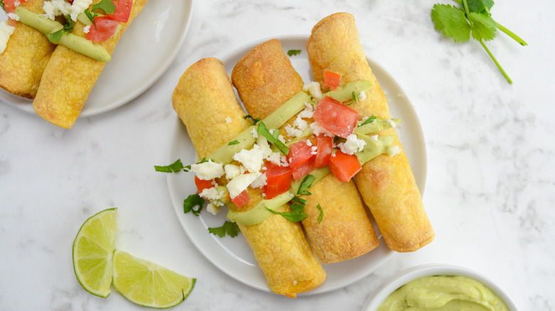plate with garnished chicken taquitos