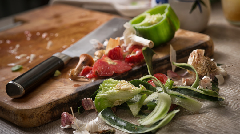 Vegetable scraps near a chopping board