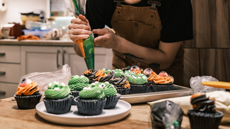 Person decorating cupcakes for a party