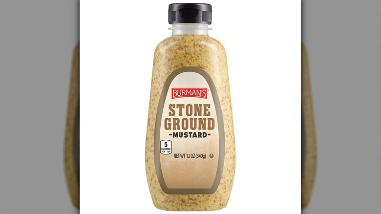 A bottle of Burman's stone ground mustard on a white background.