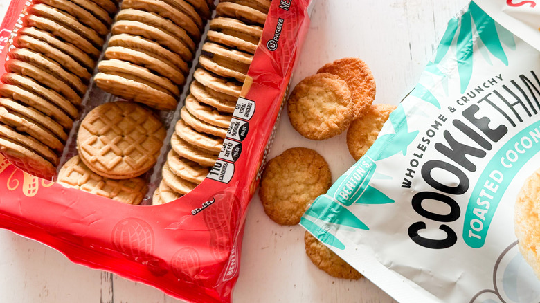 Three types of Aldi cookies with packages on a white wooden surface