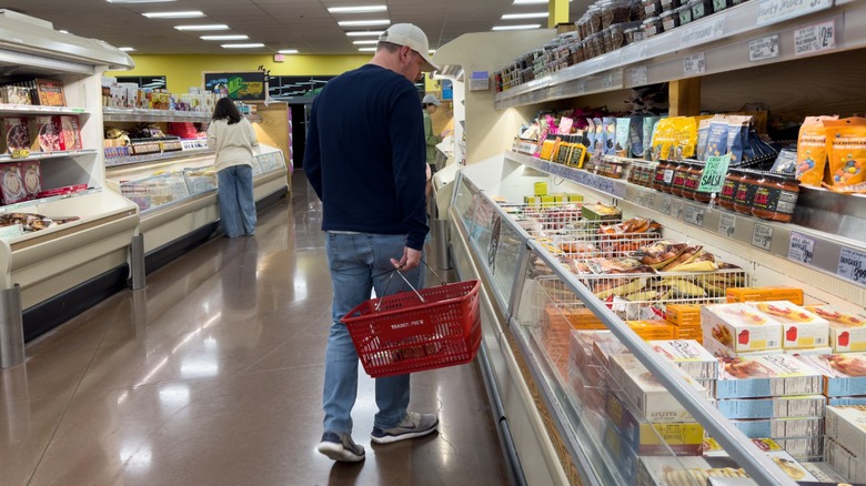 A man shopping in the frozen food aisle at Aldi