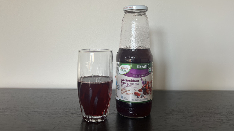Simply Nature antioxidant power 100% juice in a glass next to the bottle