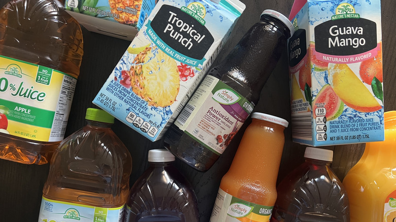 Several Aldi juices bottles and cartons laid out on a tabletop