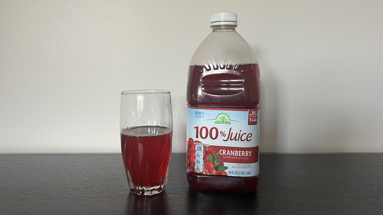 Nature's Nectar cranberry 100% juice in a glass next to the bottle