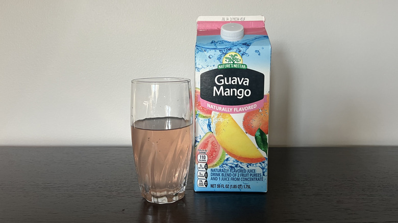 Nature's Nectar guava mango juice drink in a glass next to the carton