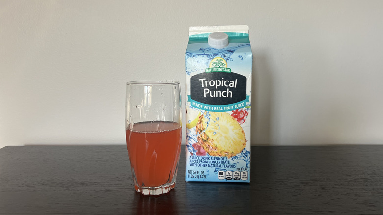 Nature's Nectar tropical punch in a glass next to the carton