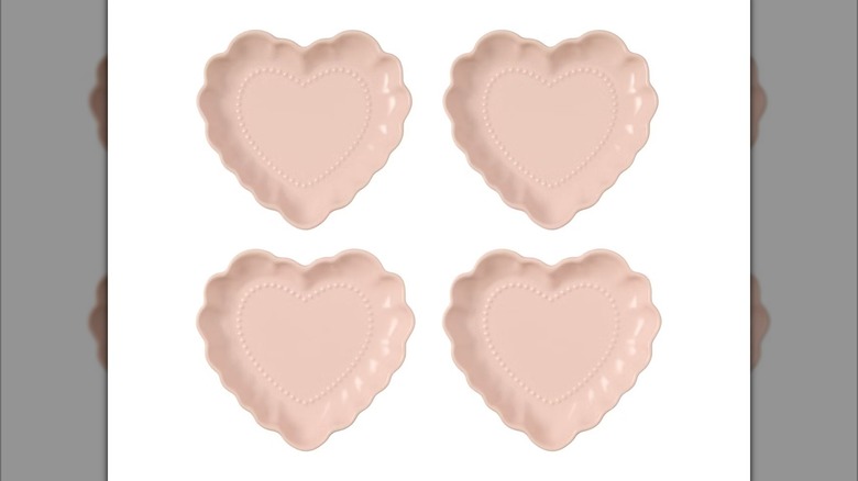 Four pink Crofton brand heart-shaped plates on white background