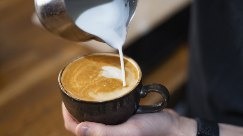 pouring creamer in coffee