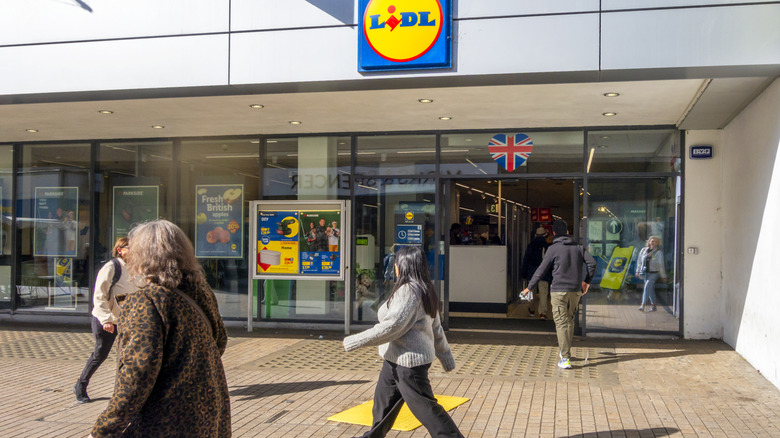 Shoppers walk outside the front of a Lidl store in the UK