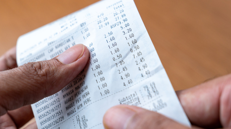 Person holding grocery store receipt