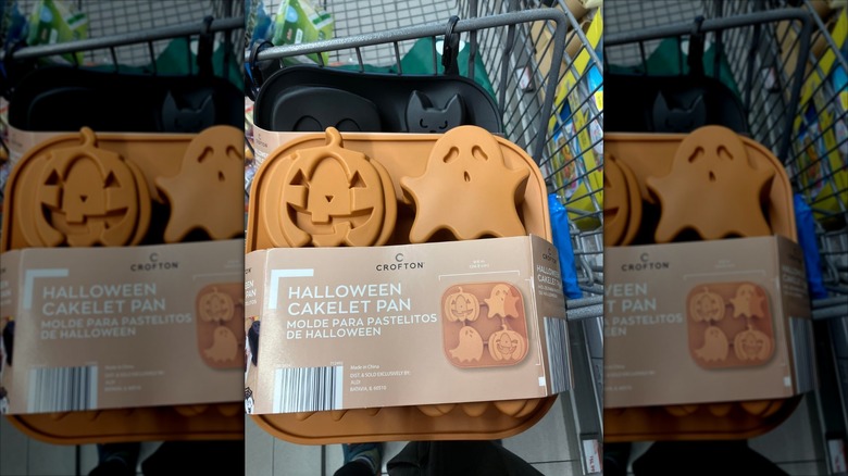 A shopping cart with Aldi's Halloween Cakelet Pans stacked inside
