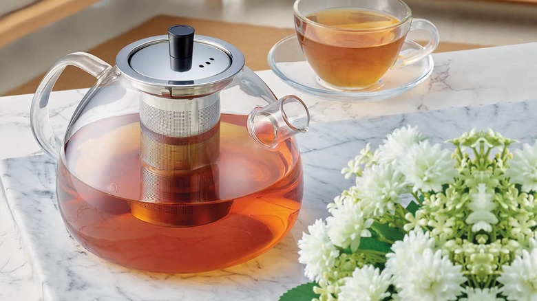 Crofton Glass Tea Pot with Glass Mug on Table.