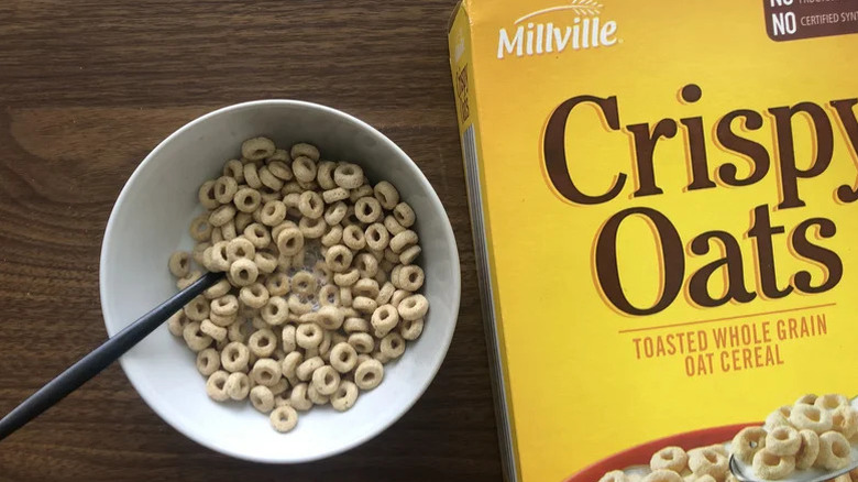 A bowl of Millville crispy oats cereal next to a box of the same