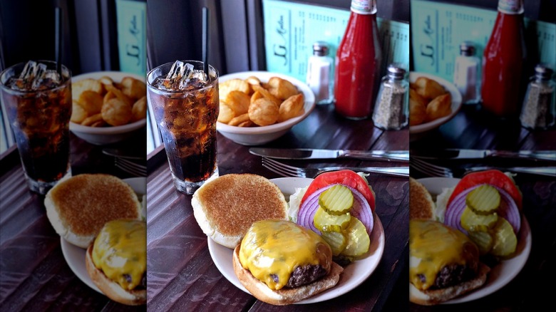 a burger with a soda and fries at JG Melon in New York City