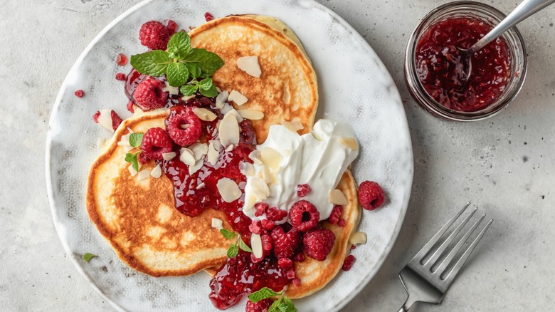 Pancakes with raspberries and raspberry compote, slivered almonds, and Greek yogurt