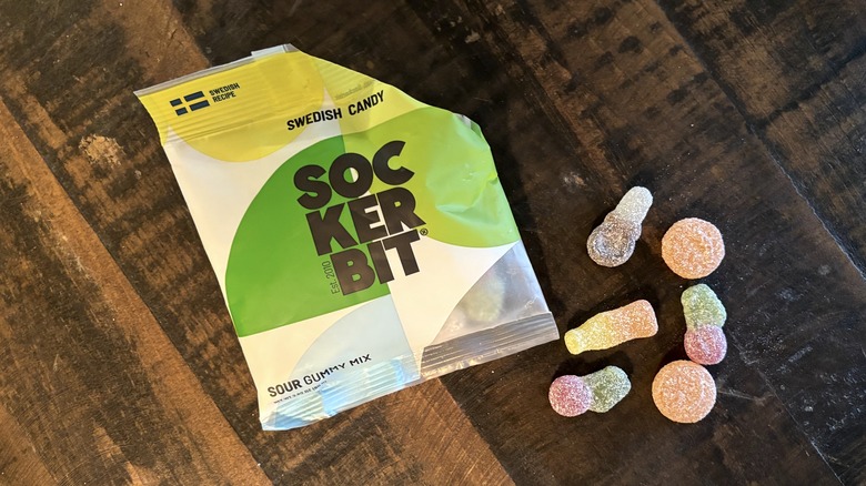 Sockerbit sour gummy mix in bag and on wooden background.