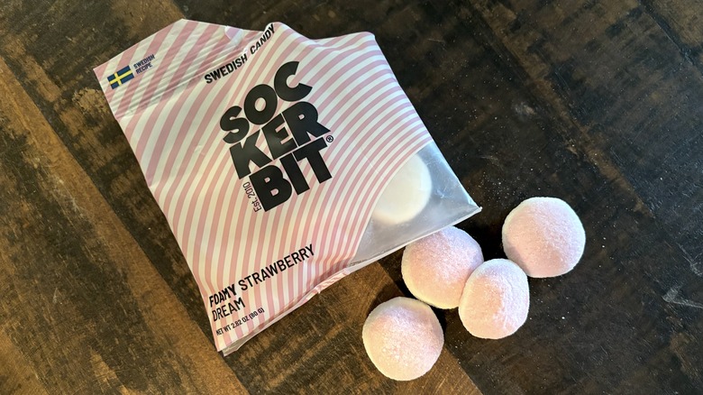 Sockerbit foamy strawberry dream in bag and on wooden background.