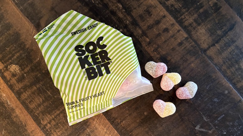 Sockerbit sour & fruity heart gummies in bag and on wooden background.