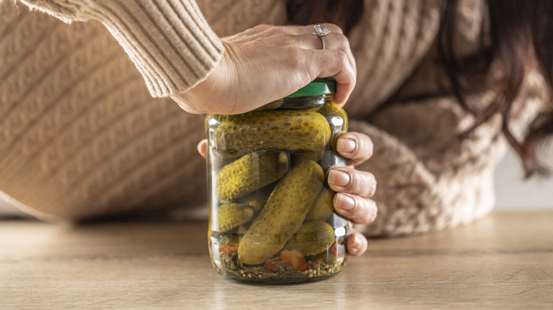 Person struggling with pickle jar.