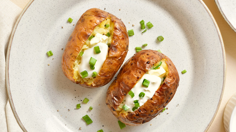 Two loaded baked potatoes on a plate