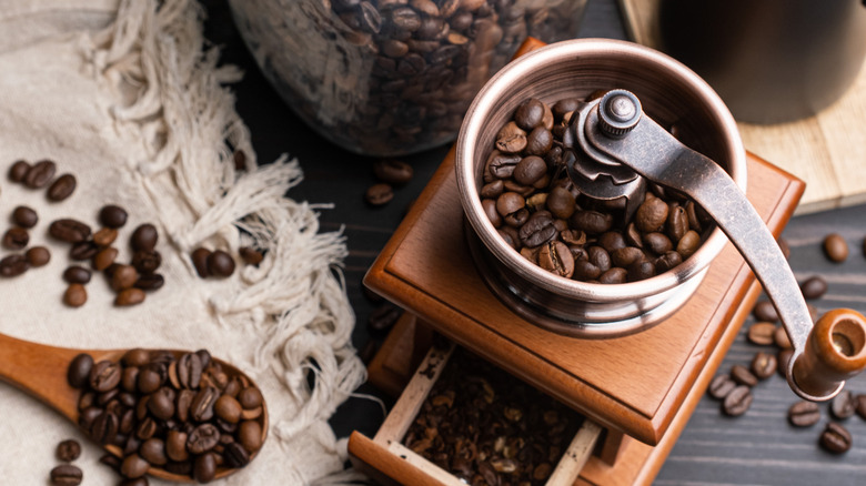 Coffee beans in hand burr grinder