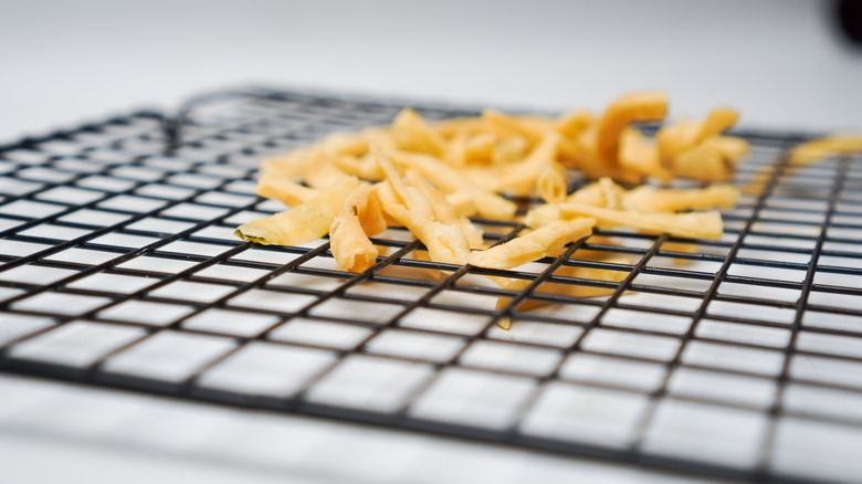 French fries on a square metal cooling rack.