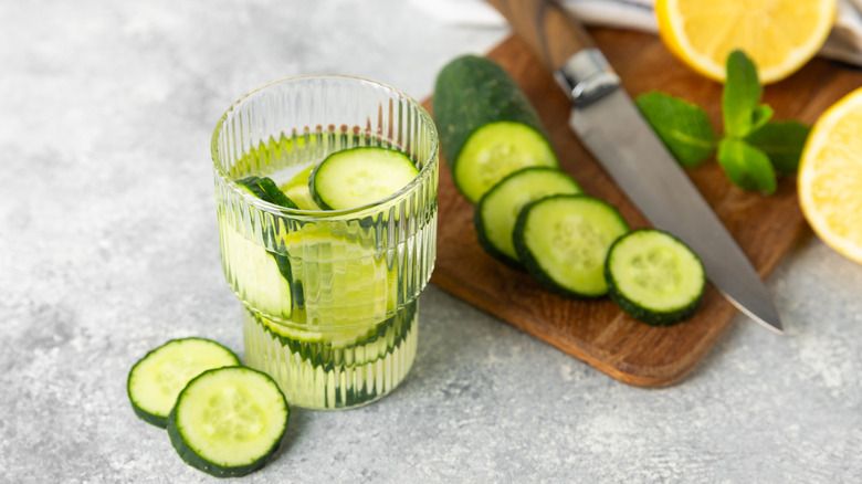 Cocktail with cutting board and cucumber slices